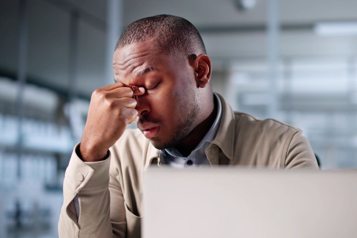 Man looking stressed while working at a laptop