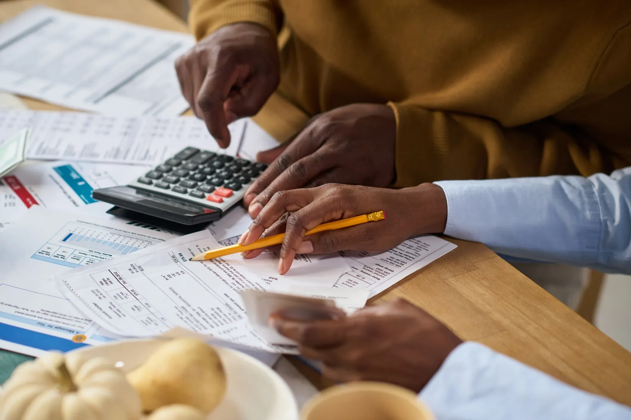 Two people reviewing household finances with a calculator